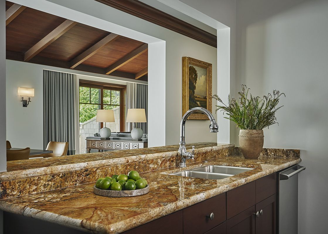 A close-up view of the kitchen in the Montage Flagstaff Suite, showcasing the polished granite countertops, a double stainless steel sink, and a modern chrome faucet.