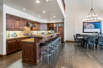 The modern kitchen features sleek stainless steel appliances, granite countertops, and a breakfast bar with seating.