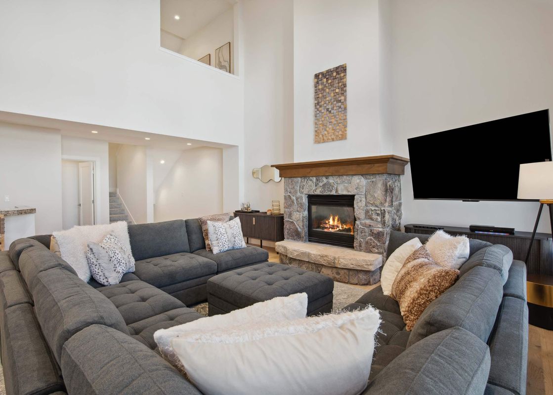 A living room with a sectional sofa, fireplace, and TV.