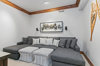 The comfortable living area in Grand Lodge 3 Bedroom Deluxe 304 features a sectional sofa and a large artwork above the fireplace.