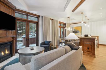 The living room of The Aspen 03B featuring a fireplace and a large sectional sofa.