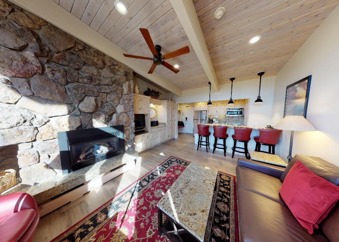 Manor Vail 364 living room, featuring a gas fireplace, a large leather sofa, and a coffee table.
