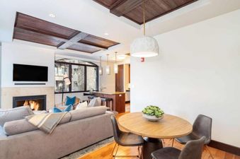 A spacious living area in Lumiere One Bedroom Standard Residence with a fireplace, a couch, and a coffee table in the living area.