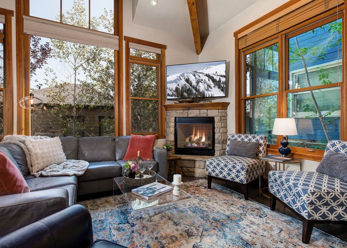 The living room at Abode at Dawn Patrol offers a warm and inviting space with plush seating and a stone fireplace.