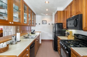 The galley-style kitchen at Plaza Lodge 2 Bedroom Silver Unit 3 features ample counter space, stainless steel appliances, and wood cabinetry, creating an inviting culinary environment.