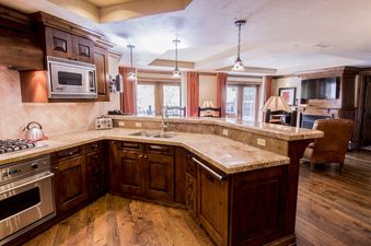 A spacious and inviting kitchen with dark wood cabinets, light granite countertops, and stainless steel appliances.
