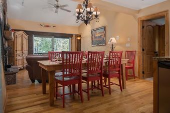 Warmly lit dining table with red chairs and hardwood floors in Whiteridge B3.