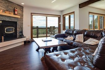 A cozy living room in the Ranch at Steamboat RA309 with a fireplace, comfortable sectional sofa, and a balcony with a view.