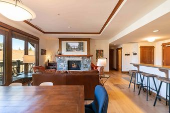 A modern living room with a fireplace, a couch, and a dining table.