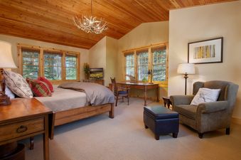 Cozy bedroom with wooden vaulted ceiling and armchair in Granite Ridge Homestead 3072.