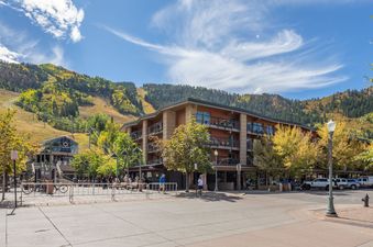 A wide-angle, eye-level photo of the North of Nell Unit 2D captures its exterior and the surroundings, showcasing its convenient location near the gondola plaza and the Aspen mountain.