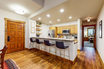 A kitchen with a breakfast bar and three bar stools.