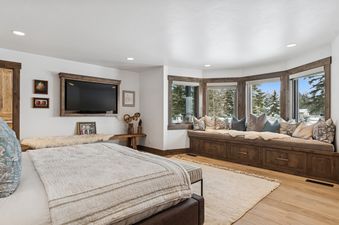 A serene bedroom retreat at Mission View Escape with a cozy window bench overlooking a snowy landscape.