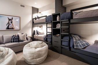 Moonlight Basin 10 Wildwood features a bunk bed with a cozy throw blanket. There are bean bag chairs in the room for additional seating.