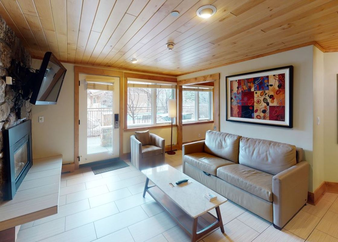 A modern living room with a leather couch, a coffee table, and a fireplace.