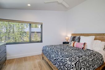 The bedroom in Moonlight Basin 12 Lake Cabin features a comfortable king-size bed with a black and white patterned comforter.