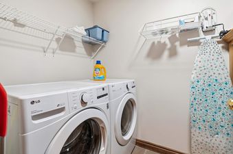 A dedicated laundry area at Highlands Slopeside 502, featuring an LG washer and dryer, shelves, and an ironing board.