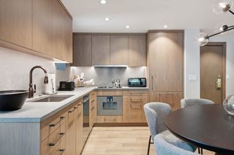Kitchen area at Lodge Tower 699 with wood cabinets and modern lighting.
