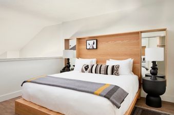 Cozy lofted bedroom of the Gravity Haus Jackson Hole Suite with a light oak headboard and a queen bed.