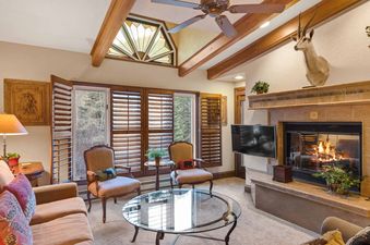 The living area of The Charter D4705 features a fireplace, comfortable seating, and large windows with outdoor views.