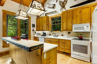 The inviting kitchen at 3137 Arrowhead features wood cabinetry and unique lighting.