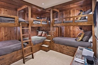 The bunk room in Three Forks Mountain One Steamboat Place 306 features four custom-built bunks with plush bedding and reading lamps, providing a cozy and functional space for guests.