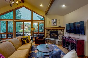 Cosy living room at Leeward 2688 with stone fireplace and large windows.
