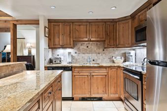 A modern kitchen with stainless steel appliances and wooden cabinets.