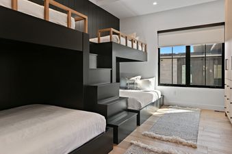 Modern bunk room with black bunk beds and built-in wooden wardrobes at SkyRidge 1843.