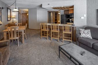 An inviting open-concept living area with a lounge, dining area, and kitchen in Building 4 One Bedroom Beaver Run Resort.