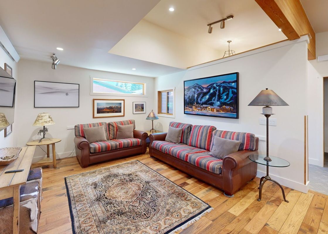 Cozy living room at Eagles Rest 5 with striped sofas and mountain-themed artwork.