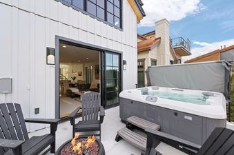 The outdoor patio at Snowbound at Kings Crown featuring a hot tub and a fire pit.