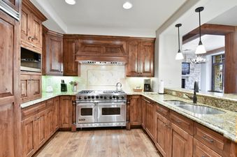 The fully equipped kitchen in Silver Strike Lodge 304 features rich wooden cabinetry, granite countertops, and modern stainless steel appliances.