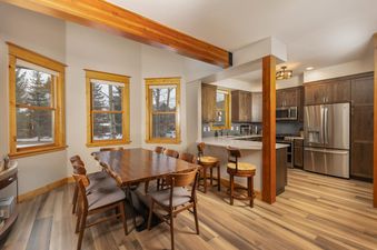 The open concept dining room and kitchen of the French Street Retreat feature rustic wood accents and stainless steel appliances.