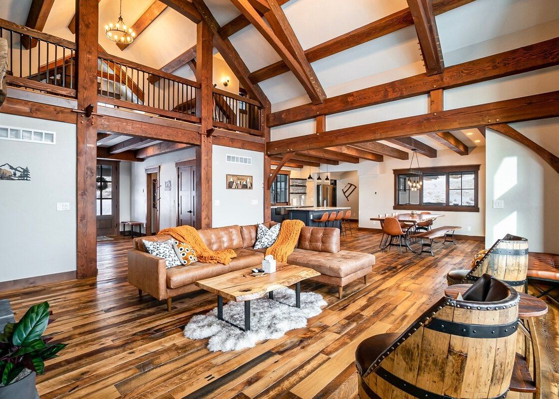 Spacious great room in the Granby Ranch Lodge with exposed wood beams, a leather sectional, and rustic-chic furnishings.