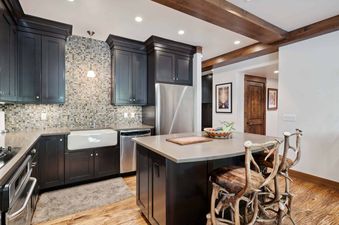 The kitchen in Woodrun Place 20 features stainless steel appliances, a farmhouse sink, and a breakfast bar.