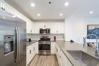 The well-appointed kitchen in Bear Creek Lodge 207 features stainless steel appliances and white cabinetry.