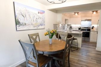 Dining table and chairs in the dining area of Gros Ventre A10, showing the kitchen in the background.