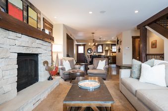 A cozy living room at Silver Star 603 with a stone fireplace, comfortable seating, and an open layout connecting to the kitchen.