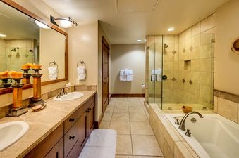 A luxurious bathroom with double sinks, a large soaking tub, and a separate walk-in shower.