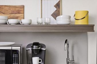 Modern kitchenette in the Gravity Haus JH Premium King Suite with a coffee maker, microwave, and open shelving.