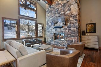 Grand Lodge 5 Bedroom Penthouse 504 living area with stone fireplace, large windows, and comfortable seating.