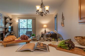 An inviting view of the dining and living area in Sleeping Indian W12, showcasing a beautifully arranged table and kitchen counter.