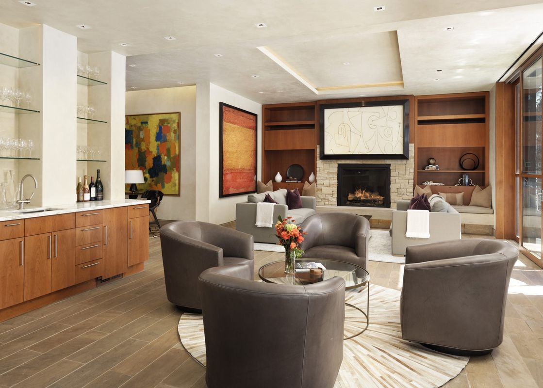 Living room interior with chairs, coffee table, and fireplace.