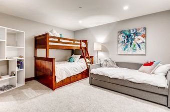 A bedroom with a bunk bed and a daybed with white bedding.