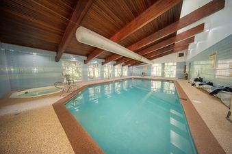 The indoor swimming pool and hot tub at Beaver Village 414 are brightly lit with natural light from large windows and overhead lighting.