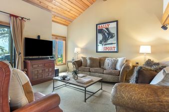 A cozy living room with a TV, comfortable couches, and a coffee table.