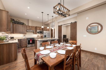 A spacious kitchen and dining area with wooden cabinetry, granite countertops, and modern appliances.