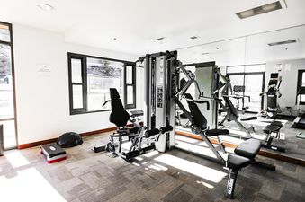 A modern gym with a variety of weight training equipment.