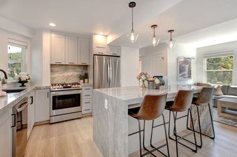 The kitchen in Abode at Kings Gold boasts marble countertops and backsplash.